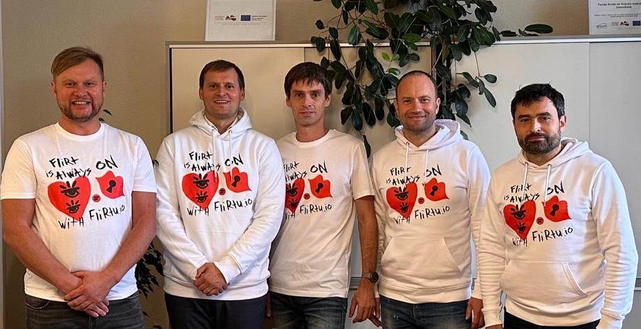 Five Flirtu team members pose in branded shirts